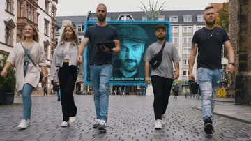 Fünf Personen gehen auf einem Platz, überlagert von einem großen Bild.
